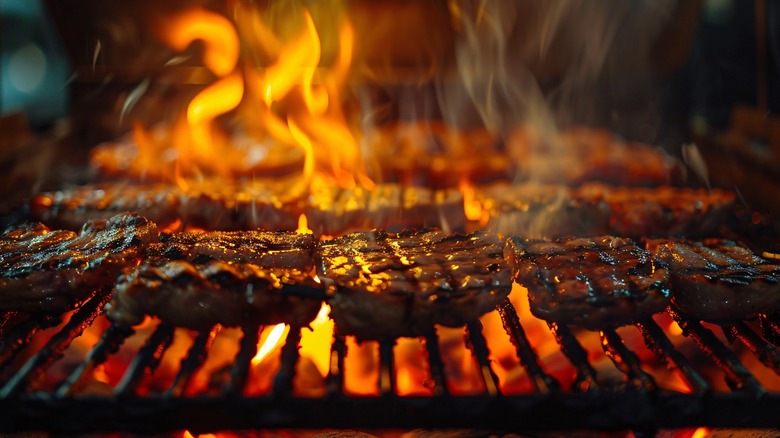 Steaks on grill with flame