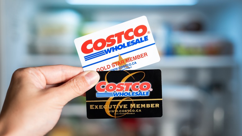 Hand holding Costco membership cards