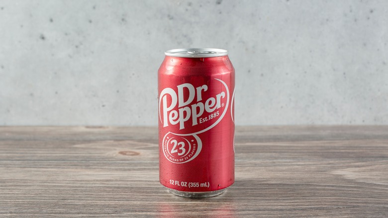 Person holding a can of Dr Pepper soda