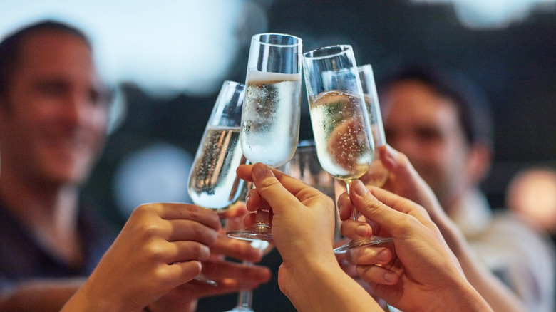 four champagne glasses toasting closeup