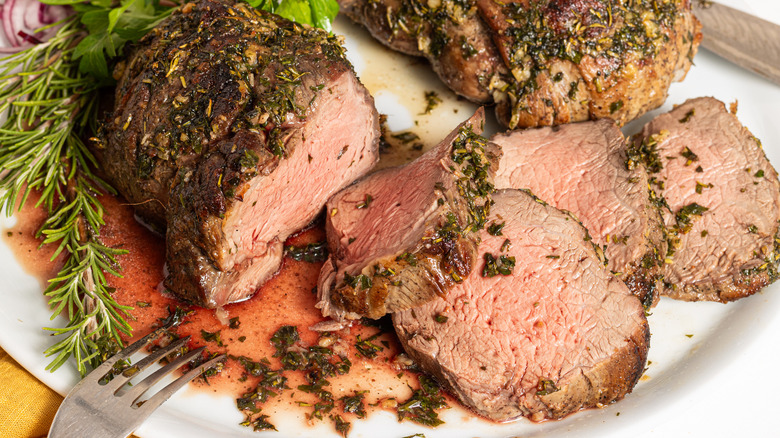 Sliced herb-roasted beef tenderloin on a plate