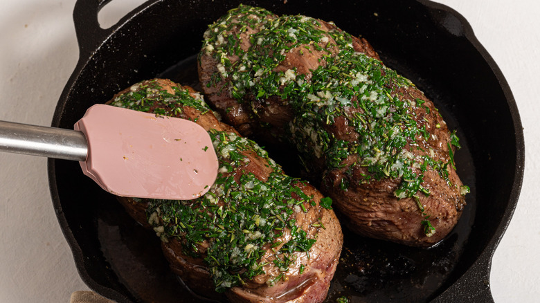 Cast iron skillet with herbs covered beed tenderloin
