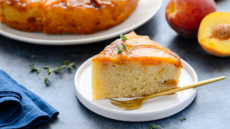 a slice of peach cake with a sprig of thyme on top