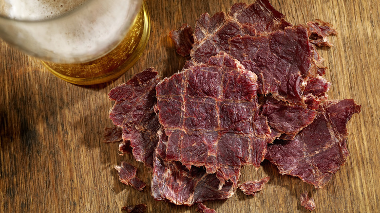 Beef jerky and beer on a wooden table