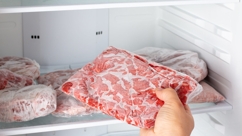 Taking frozen meat from freezer