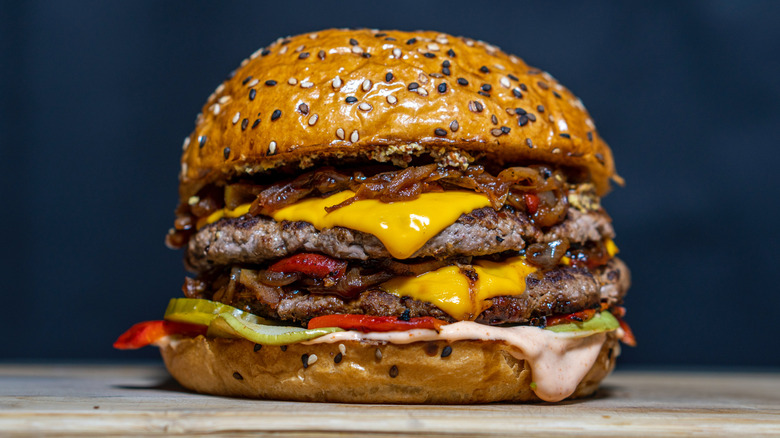 A cheeseburger on a wooden surface.