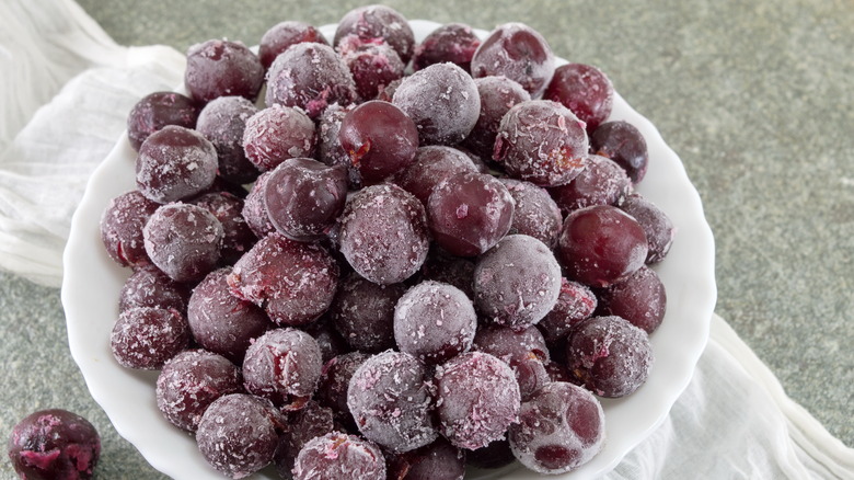 Frozen red grapes in a white bowl