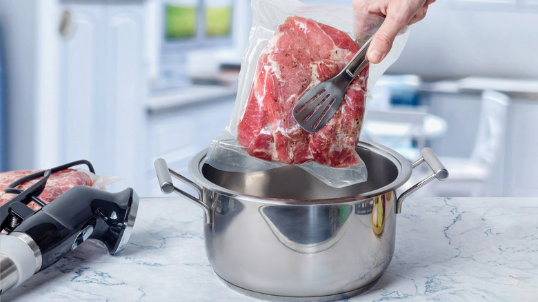 person cooking meat sous vide style