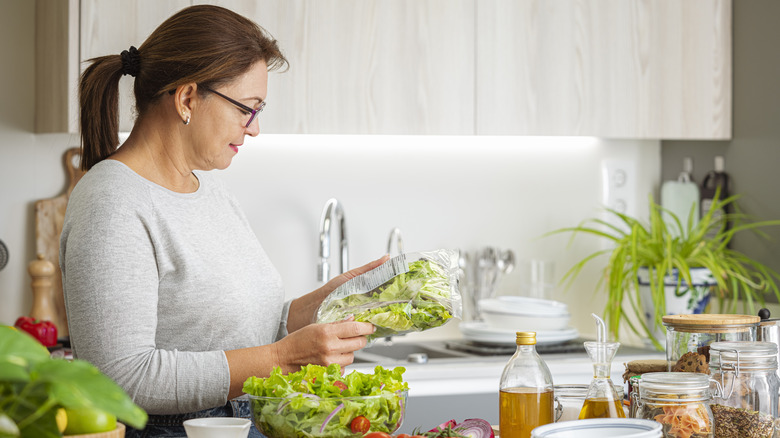 Woman making a salad with bagged lettuce