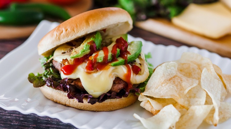 A Mexican hamburger is served with tortilla chips.