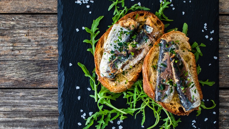 sardines on bread with arugula