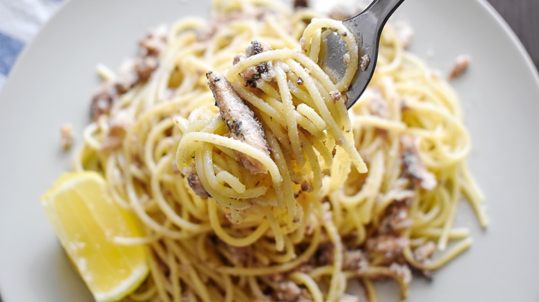 Spaghetti topped with lemon and sardines. 