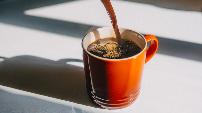 Black coffee poured in red cup