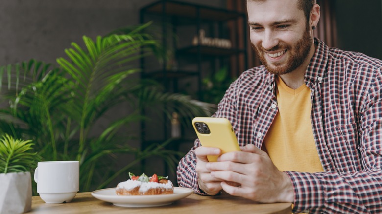 Man photographing his food in restaurant