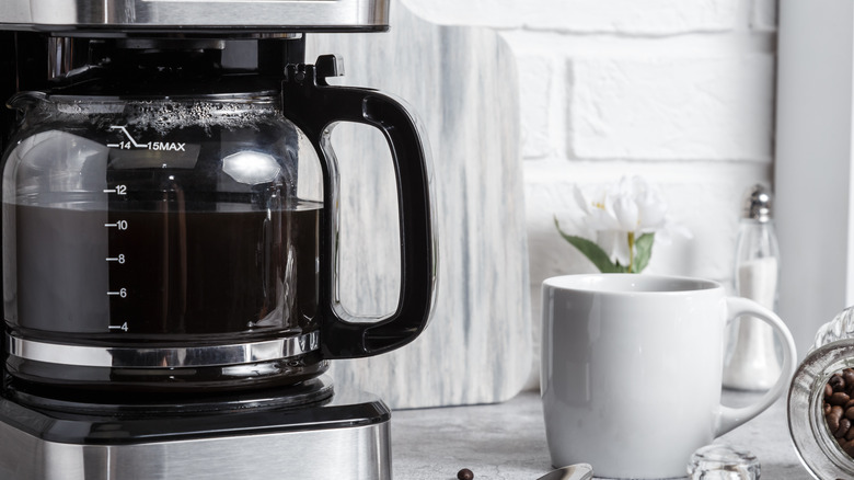 Automatic drip coffee machine with carafe filled with coffee