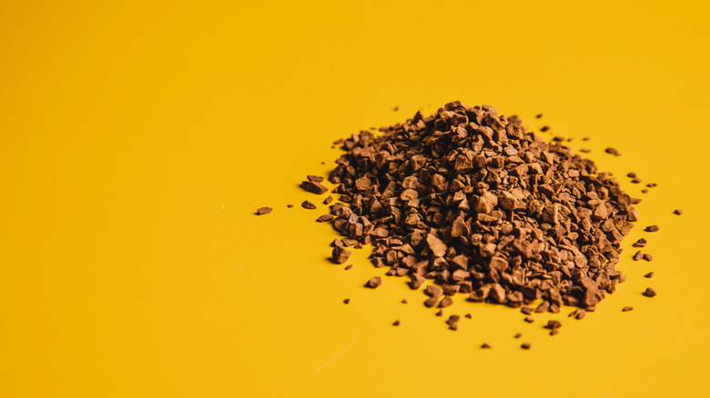 Instant coffee granules on a yellow background