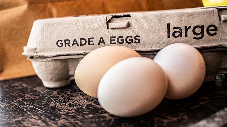 Carton of grade A large eggs with three eggs out