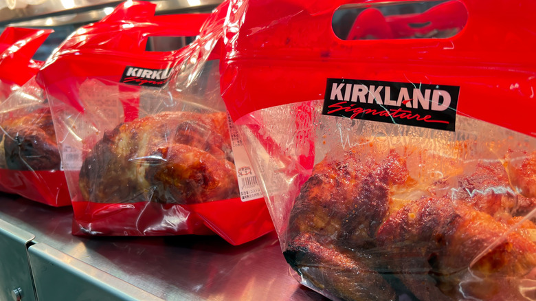 Costco roasted chickens in bags under heat lamps