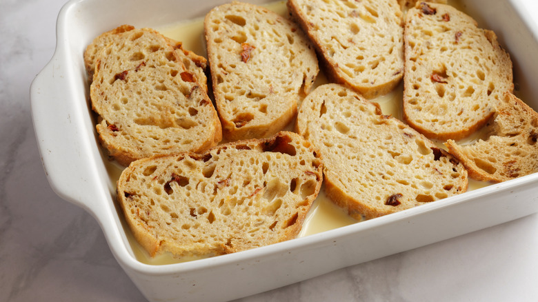 soaking bread in white baking dish