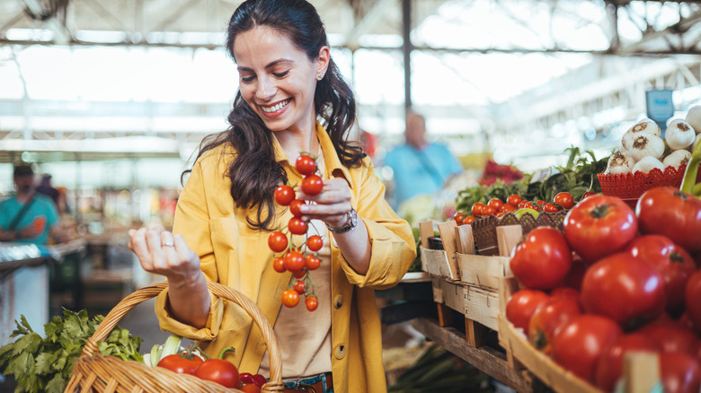 Woman putting tomatoes in basket