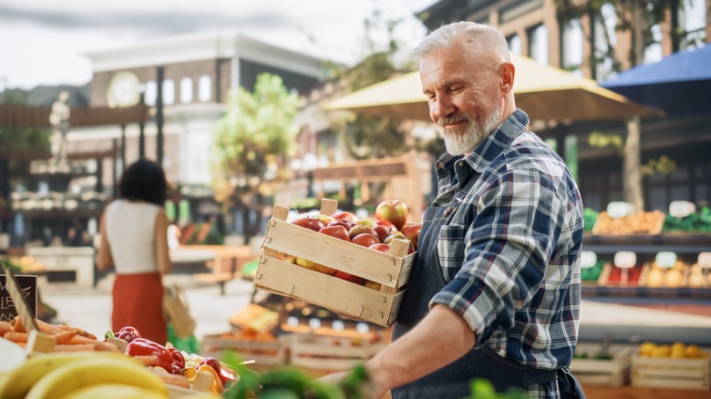 Man holding crate of apples