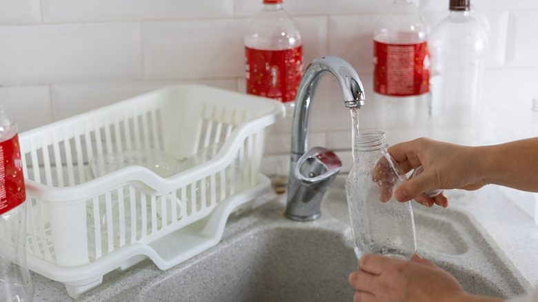 rinsing plastic water bottle in sink