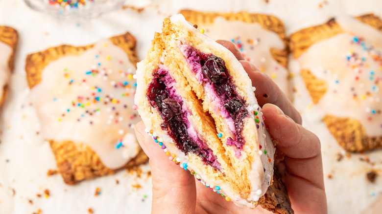 Holding blueberry cheesecake Pop-Tart in half