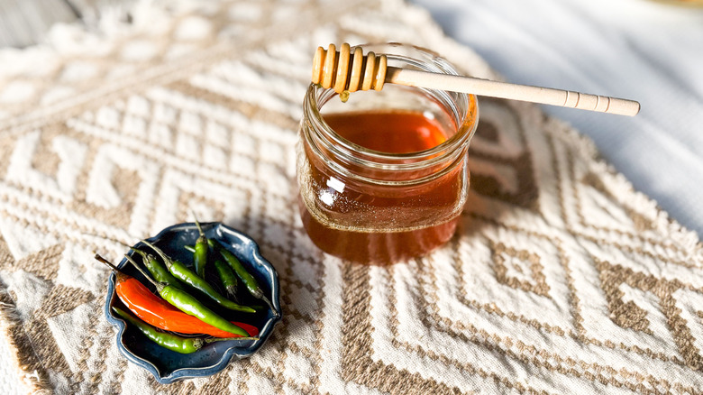 Homemade hot honey with chiles and honey dipper