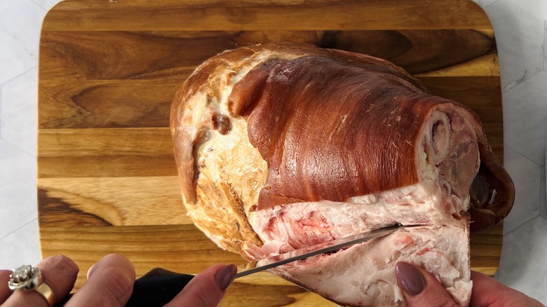 hand cutting rind off ham