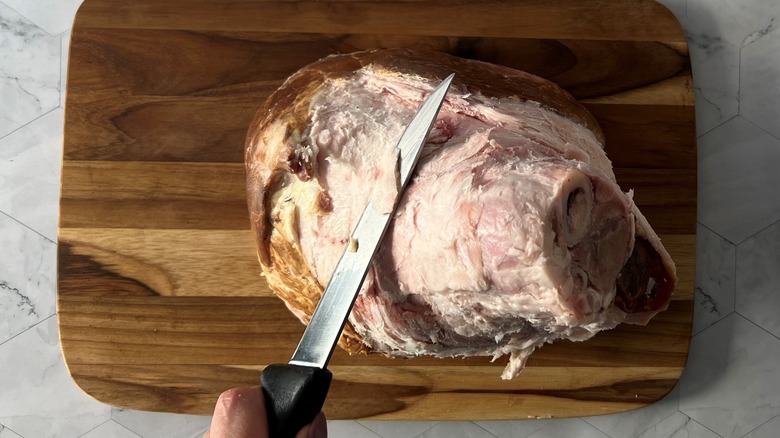 hand with knife and ham