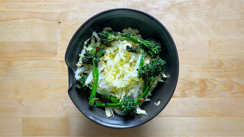 Napa cabbage and broccolini in serving bowl over rice