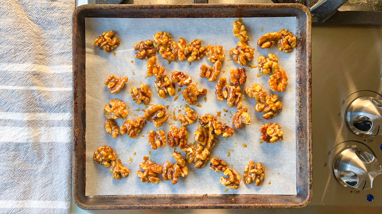 Honey walnuts on parchment paper on sheet pan