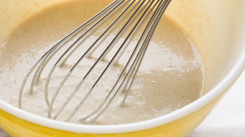 A whisk in pancake batter