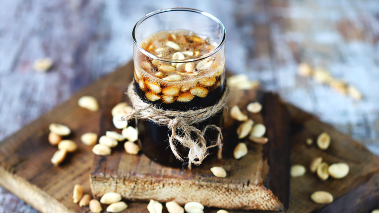 glass of soda with roasted peanuts