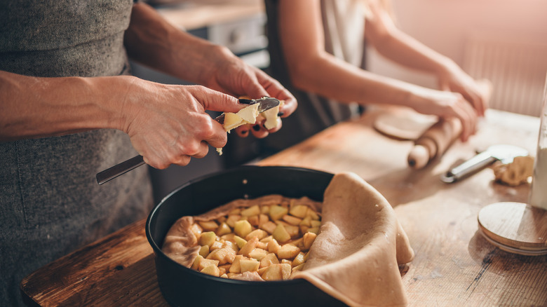 Mother and daughter making apple pie