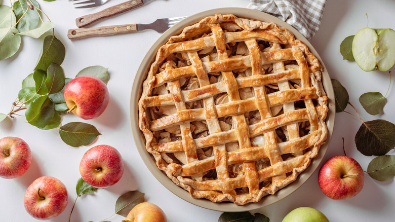 Apple pie surrounded by apples