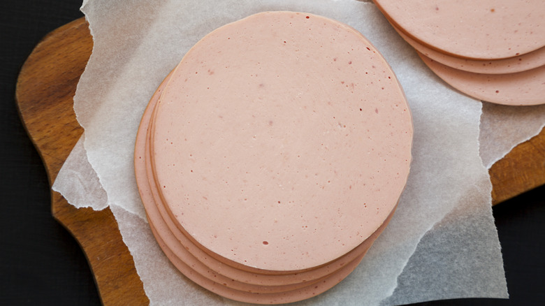 Stack of bologna slices on a wooden board