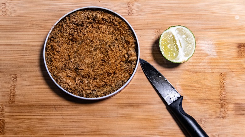 A rimming tray of ground spices with a halved lime