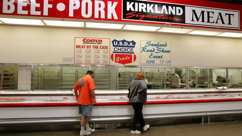 Two customers perusing Costco's meat department