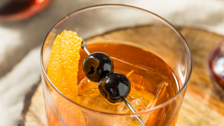 bourbon cherries on a cocktail with a wedge of lemon