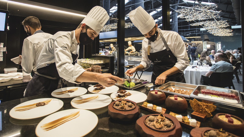 Chefs plating dishes in a fine dining kitchen