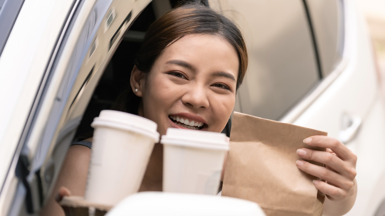 woman with bag of takeout at drive thru