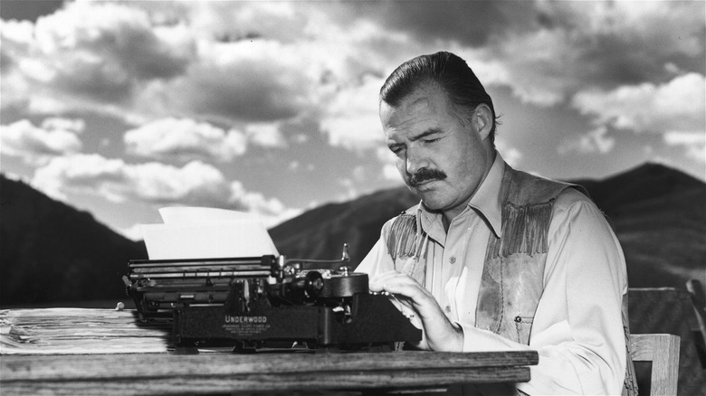 Ernest Hemingway typing on his typewriter outdoors