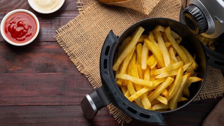 Fries in air fryer with condiments