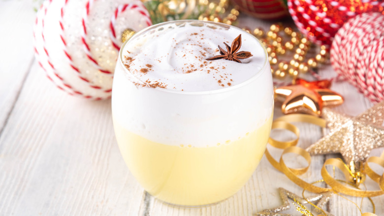 Hot eggnog with star anise and holiday ornaments