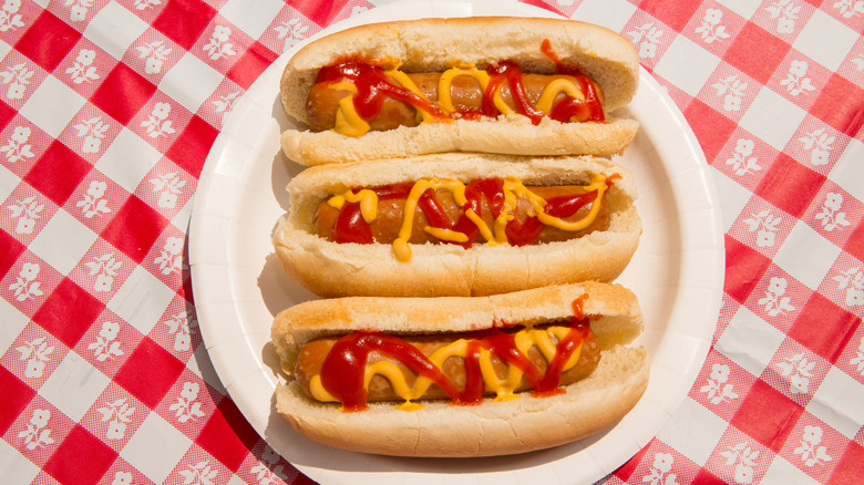 Plate of Three Hot Dogs on Checkered Tablecloth