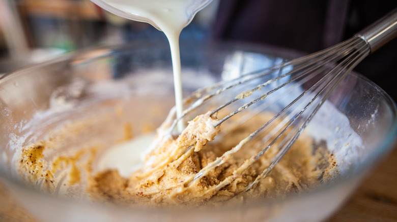 close up of a cake batter with a whisk in the bowl