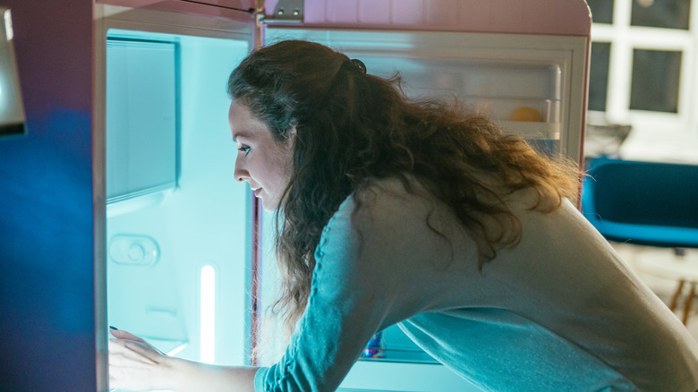 woman opening fridge