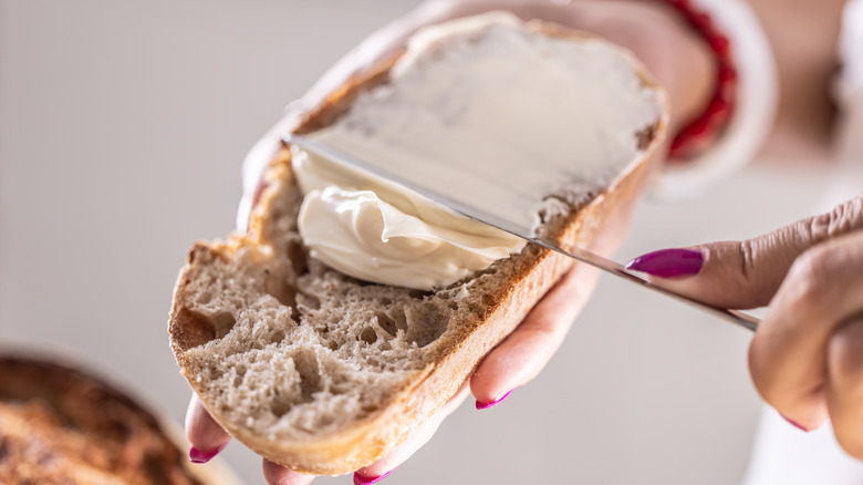 Person spreading cream cheese