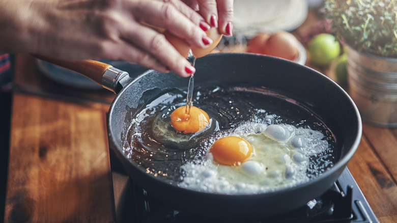 Cracking eggs into a pan